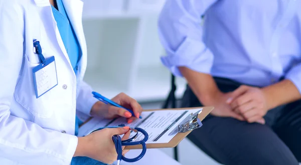 Doctor woman sitting with male patient at the desk